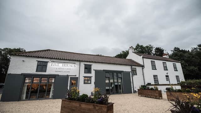 Five Houses Farm Shop & Kitchen, a charming café with a white exterior, large windows, and flower planters in Crathorne.