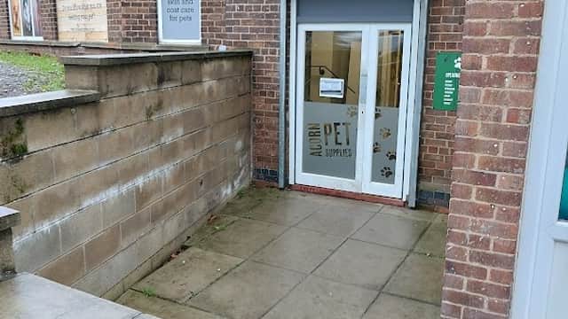 Entrance to Acorn Pet Supplies, featuring a glass door with "PET SUPPLIES" signage and a paw print logo.