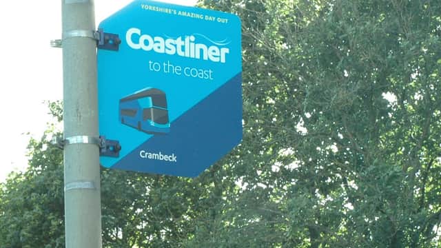 Coastliner bus stop sign in Crambeck, Yorkshire, with trees in the background.