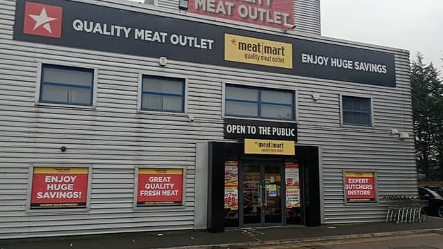 Quality Meat Outlet storefront with large signs advertising savings, open to the public, and expert butchers inside.