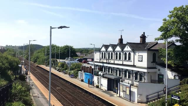 Co-op store and railway station in Pannal, surrounded by greenery and clear blue skies. Train tracks visible.
