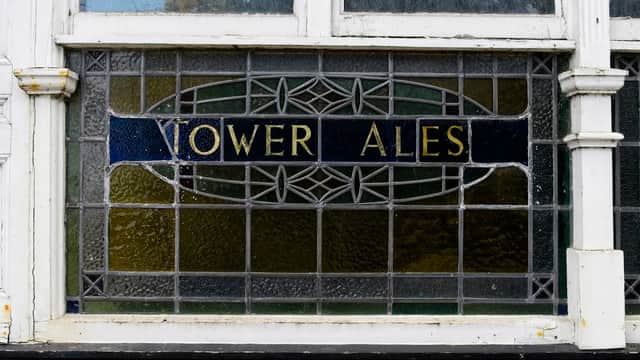 Stained glass window displaying "Vower Ales" with decorative patterns in a shopping centre.