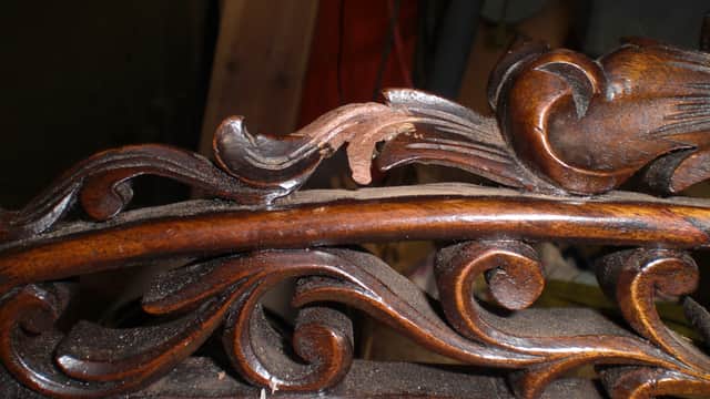 Intricate wooden carving with ornate floral designs on a furniture piece, showcasing craftsmanship in Ainderby Steeple.