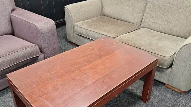 Two sofas in a cozy seating area with a wooden coffee table on a dark carpet.