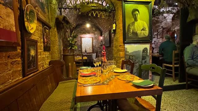 Cozy restaurant interior with wooden tables, vintage decor, and South African flags hanging from the ceiling.