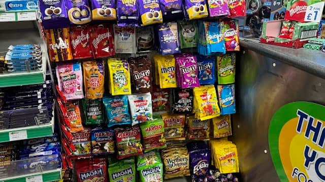 Colorful display of snacks and sweets in a convenience store, with various brands and types prominently arranged.