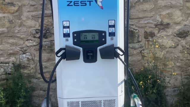 Zest Charging Station with a blue and white design, located against a stone wall in Pickering, Yorkshire.