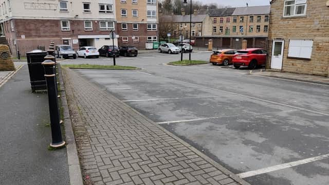 Pay & Display parking lot in Farsley, Yorkshire, with empty spaces, residential buildings, and parked cars.