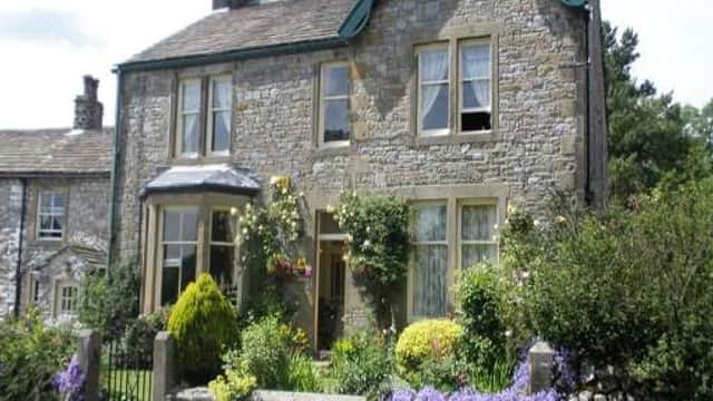 Charming stone guest house with flower-filled garden, surrounded by greenery in Kirkby Malham, Yorkshire Dales.
