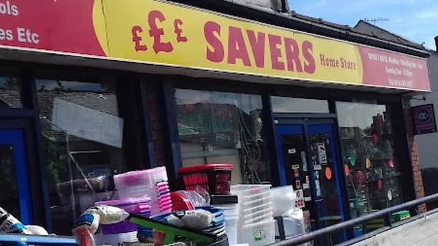 Bright red sign reading "SAVERS Home Store" above a storefront with various household goods displayed outside.