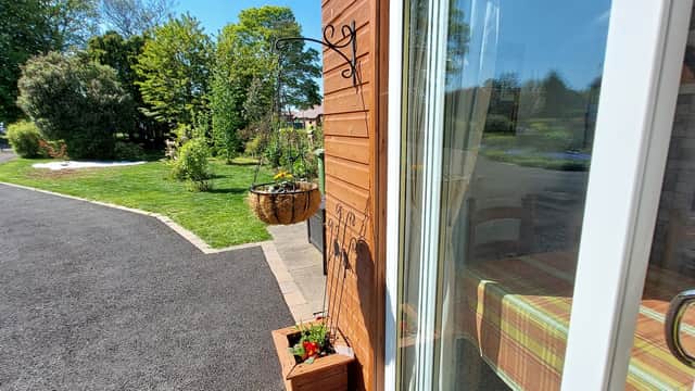 Bright exterior of The Roost Retreat with lush greenery, a flower basket, and a welcoming pathway in Leeming Bar, Yorkshire.