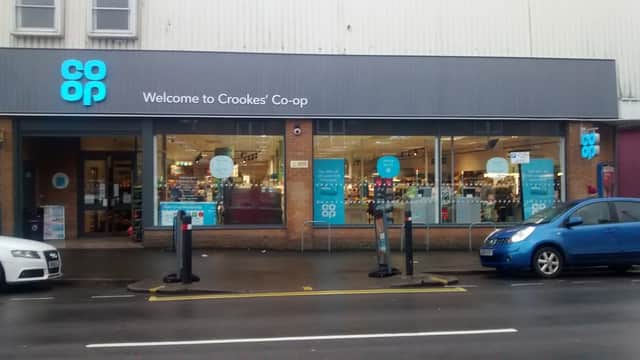 Co-op Food store in Sheffield with large windows, welcoming sign, and parked cars outside.