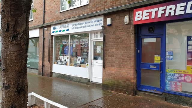 Keal Teamwear storefront with sports uniforms displayed, next to a Betfred shop in York, Yorkshire.