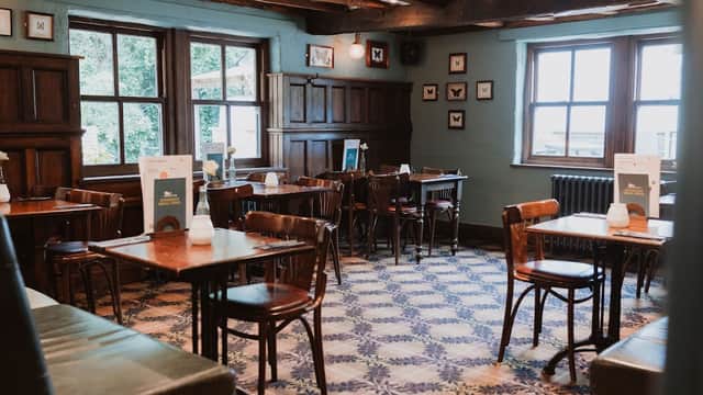 Cozy restaurant interior with wooden beams, patterned floor, and tables set for dining in Mosborough, Yorkshire.