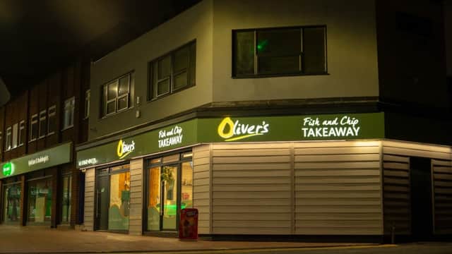 "Oliver's Fish & Chip Takeaway with bright signage, located on a quiet street in Redcar, Yorkshire at night."