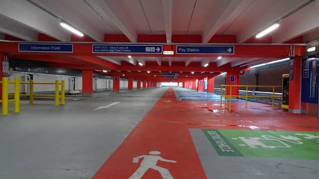 Multi-storey car park interior with clear signage, painted pedestrian paths, and an information point.