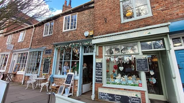 Charming bakery with brick facade, outdoor seating, colorful window displays, and chalkboard menus in York, Yorkshire.