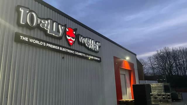 Signage for "Totally Wicked" with a red and white exterior, set against a twilight sky in Brighouse, Yorkshire.