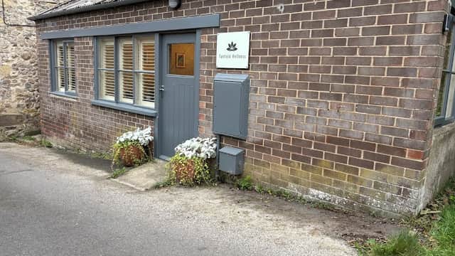 Biodynamic craniosacral therapy clinic with brick exterior, gray door, and potted plants in West Tanfield, Yorkshire.