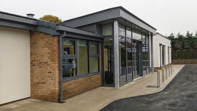 Modern library and café building with large glass windows, brick exterior, and accessible entrance in Wigginton, Yorkshire.