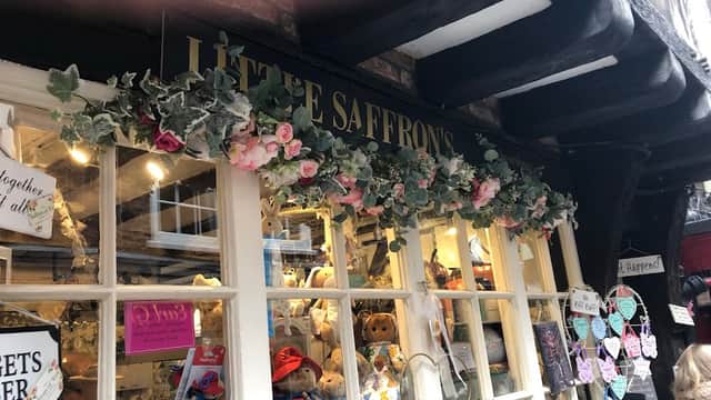 Charming gift shop entrance with floral decor, teddy bears, and colorful signs in York, Yorkshire.