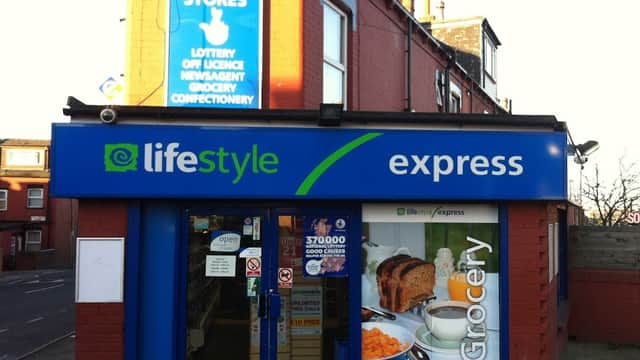 Bright blue storefront with "Lifestyle Express" signage, featuring grocery and confectionery offerings. Lottery and newsagent signs above.