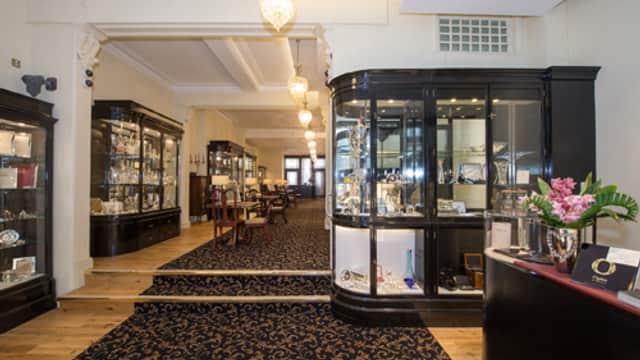 Elegant jewellers showcasing glass display cases, polished wooden floors, and decorative lighting in a spacious interior.