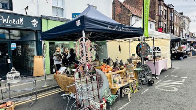 Stalls filled with goods, including decorative items and produce, line a street in Driffield Thursday Market.