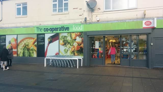 Co-op Food shop exterior with green signage, shopping carts outside, and colorful food images on the windows.
