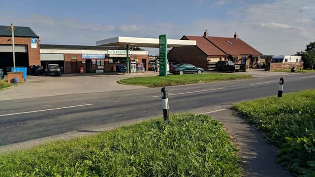 North Cowton Service Station with a shop, fuel pumps, and parked vehicles along a rural road in Yorkshire.