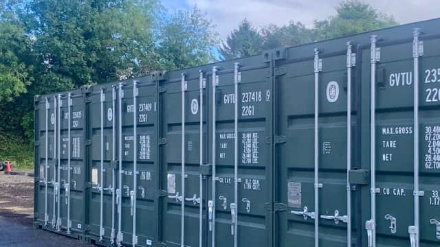 Storage containers lined up outdoors, surrounded by trees and a cloudy sky in Balby, Yorkshire.