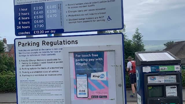 Welcome sign for the Station Long Stay Car Park, with tariffs, parking regulations, and a ticket machine nearby.