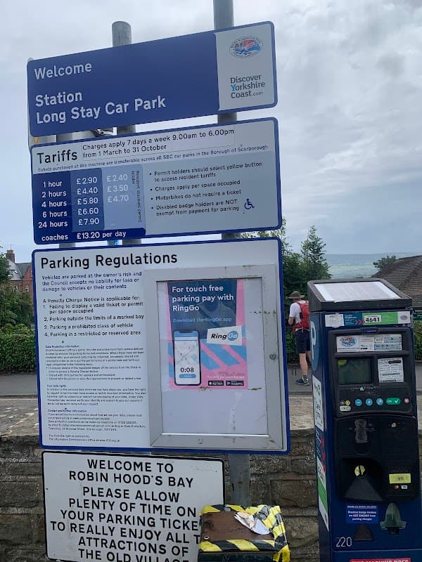 Welcome sign for the Station Long Stay Car Park, with tariffs, parking regulations, and a ticket machine nearby.