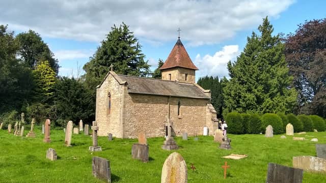 Chapel of Rest surrounded by gravestones and lush greenery under a partly cloudy sky in Brompton-by-Sawdon.