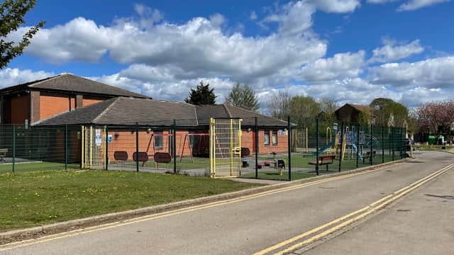 Eversley Park Centre with playground equipment, green space, and blue sky dotted with clouds in Sherburn in Elmet.