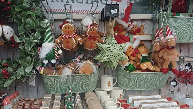 Festive decorations and gifts, including gingerbread figures, wreaths, and Christmas-themed items on display.