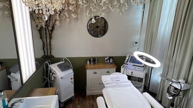 Elegant treatment room with a chandelier, modern equipment, and a relaxing ambiance featuring floral decor.