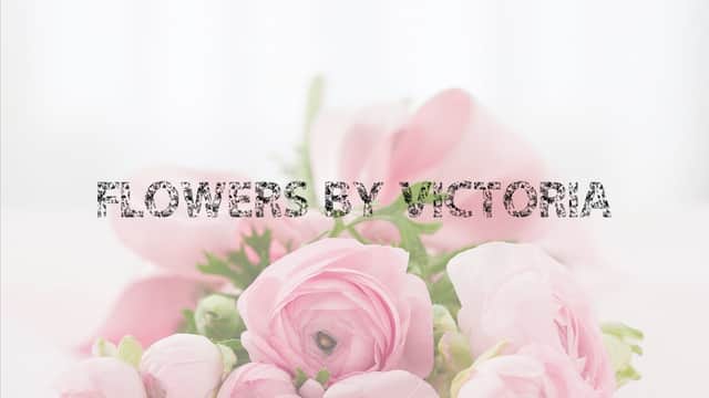 Delicate pink flowers arranged beautifully with the text "Flowers By Victoria" overlaying the composition.