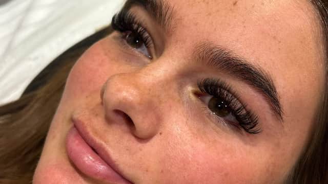 Close-up of a woman with long eyelashes and well-groomed brows, showcasing a beauty treatment at Glow Up Lash and Brow Lounge.