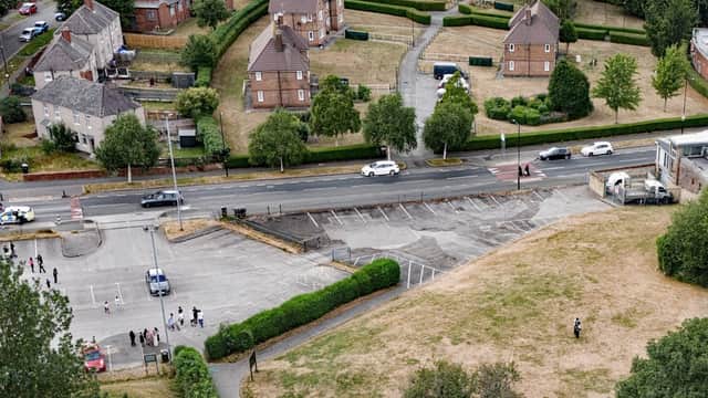 Aerial view of Firth Park Car Park with vehicles, grassy areas, and residential buildings in the background.