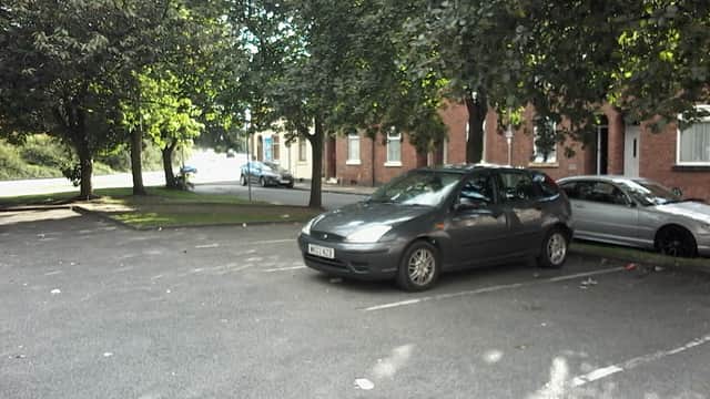 Free parking area with several cars and trees lining the edges in Wakefield, Yorkshire.
