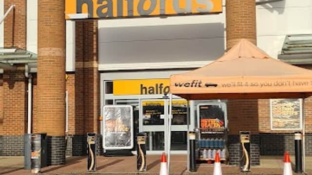 Halfords store entrance with large signage, orange awning, and traffic cones outside in Waterthorpe, Yorkshire.