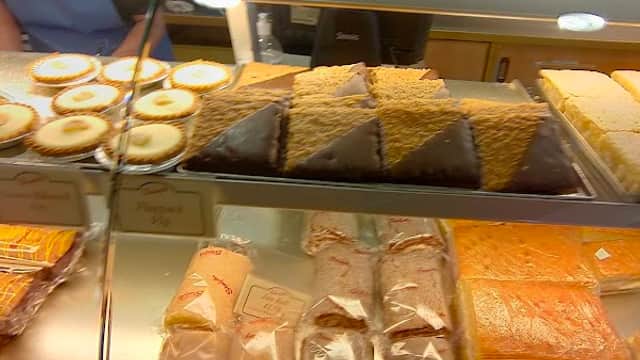 Display case filled with various baked goods, including cakes, pastries, and loaves of bread at Staniforths Ltd.