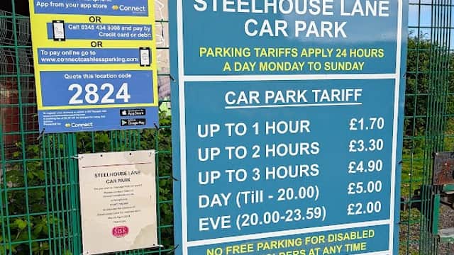 Signage detailing parking tariffs at Steelhouse Lane Car Park, Sheffield, with pricing for various durations displayed.
