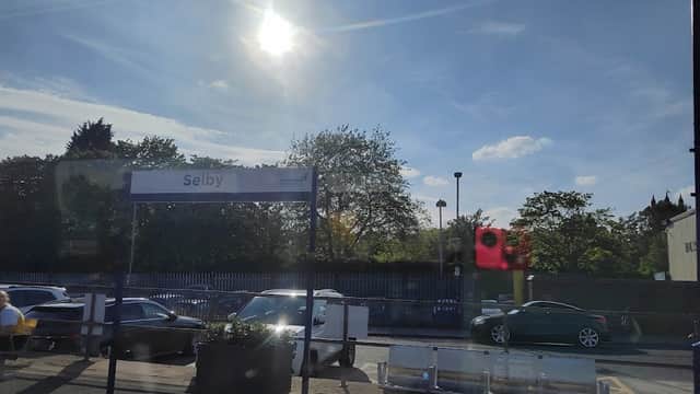 Pay & Display car park at Selby Station, with bright sun, blue sky, and parked cars visible.
