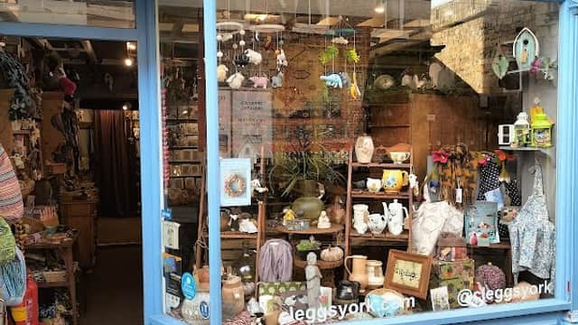Colorful homeware store window featuring various decorative items, plants, and gifts, with a blue exterior.