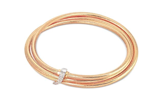 Elegant gold and rose gold twisted bracelet with a diamond accent, displayed on a white background.