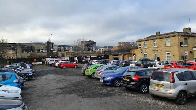 Aspley £4 Car Park filled with various parked cars, surrounded by buildings and a cloudy sky.
