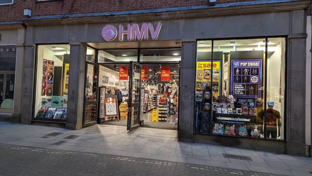 HMV store front in Harrogate, featuring colorful signage, sale posters, and a variety of music and merchandise displays.
