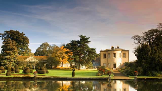 Thorp Perrow features manicured gardens, a tranquil lake, and a historic building surrounded by lush trees.